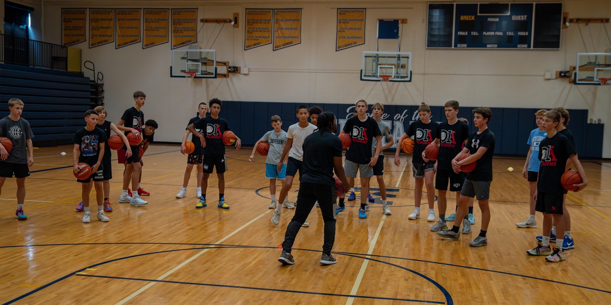 Coach and players doing skills work on basketball court